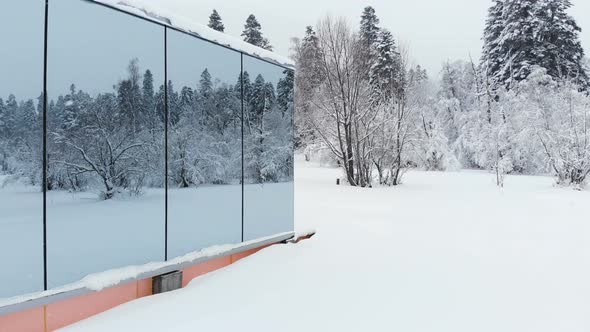 Aerial View of an Innovative Hi-tech House with Mirrored Transparent Walls in Winter Near a alt