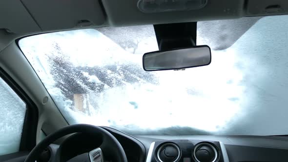 Cleaning Car Windshield of Snow