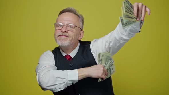 Happy elderly man with money in his hands. Dollar bills in the hands of an old cheerful man.  alt