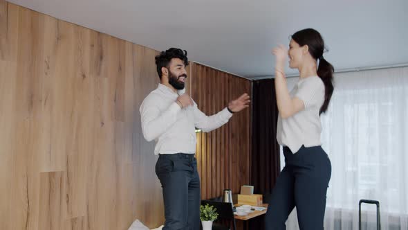 Joyful Young People Husband And Wife Dancing On Hotel Bed Undressing
