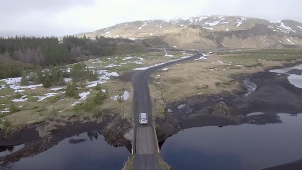 Aerial view of a car driving on a countryside road in Iceland