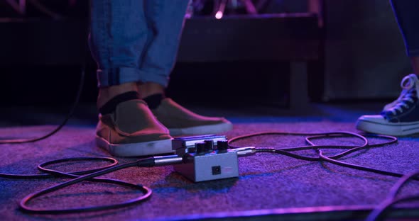 Female musician preparing her guitar before concert alt