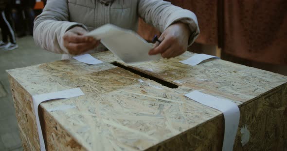 Unidentifiable person casting a ballot during elections