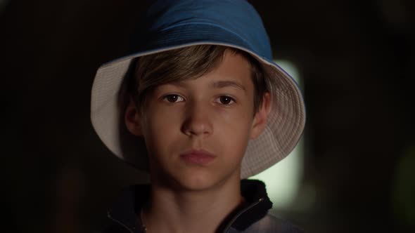 Portrait of a Sad Serious Boy in Blue Hat Looking at the Camera Indoors