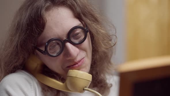 Closeup of Romantic 1980s Man Looking at Picture and Talking on Vintage Telephone alt