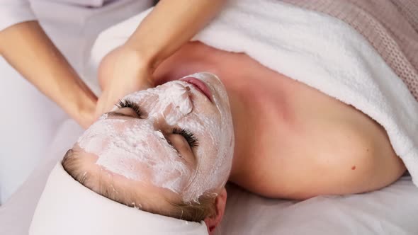 Beautician cosmetologist makes a massage of the cervical collar zone of the décolleté alt