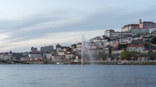 Timelapse of Coimbra at sunset with color light fountain in mondego river, in Portugal alt