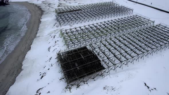 People walking under wooden dry fish rack Hovden beach in Norway, Revealing scenery mountain landsca alt