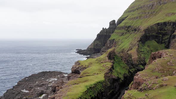 Aerial Back View of Huge Cliffs in Faroe Islands Green Rocky Mountainpowerful Ocean Wavesin a Cloudy alt