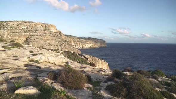 Walking on Top of Blue Grotto Caves When Evening Sun Casts Warm Yellow Light on Ground