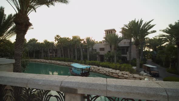 Small Wooden Boat Driving Down Water Canal in Luxury Resort in Dubai alt