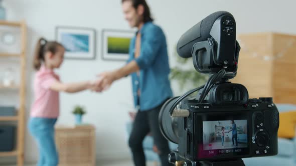 Closeup of Videocamera Screen and Family Father and Daughter Dancing and Showing Thumbsup alt