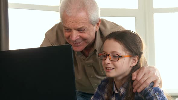Little Girl and Her Grandpa Have Video Chat on Laptop