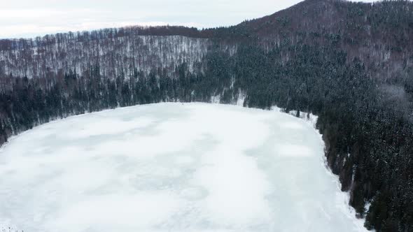 Volcanic Crater Lake Of Saint Anne Covered In Ice And Surrounded With Pine Forest At Winter In Hargh alt