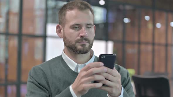 Portrait Shoot of Young Man Scrolling on Smartphone alt