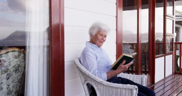 Woman reading a book in balcony at home 