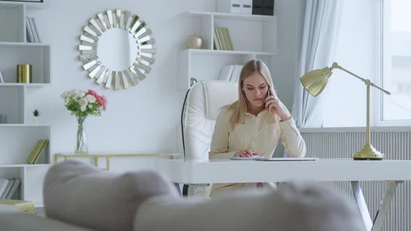 Young woman talking on the phone at home office alt