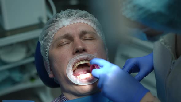 High Angle View of Caucasian Patient with Closed Eyes Sitting in Hospital As Dental Assistant alt