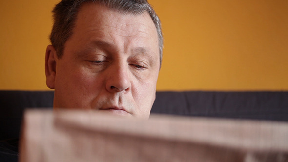Middle-Aged Man Reads Newspaper alt