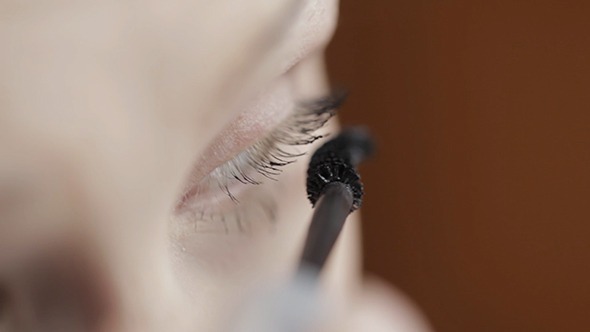 Young Woman Is Making Up Her Eyes alt