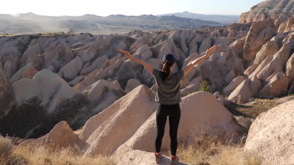 Young girl admires amazing view of Red and Rose valley, Caapadocia, Turky alt