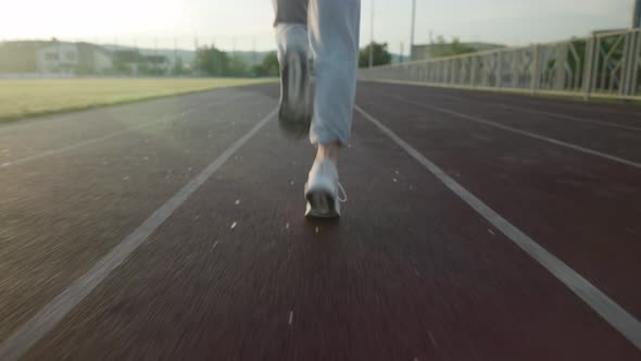 Young Beautiful Girl in Sweatpants and an Orange Tshirt Goes in for Sports alt