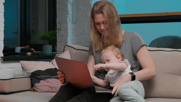Mom or Mother and Daughter Are Watching Video or Website on Silver Laptop. Daughter Cries, Is alt