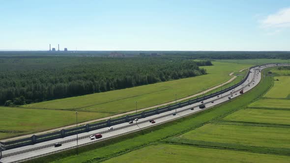 Asphalt Speedway with Cars Through Green Field. Aerial View From Drone alt