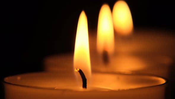 Candles close-up set on black background.Candle flame. alt