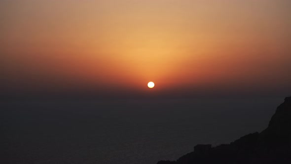 sunset timelapse over dingli cliffs in malta europe showing orange sun with soft color gradations alt