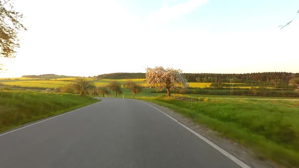 Car driving in spring time in rural countryside alt