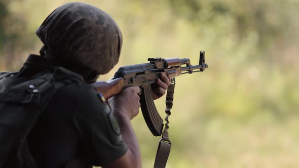 Military Man in Green Uniform Vest Unloading Gun with Machine Gun in Hand Soldier alt