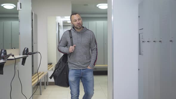Confident Athletic Man Entering Dressing Room in Gym and Opening Locker. Portrait of Caucasian alt