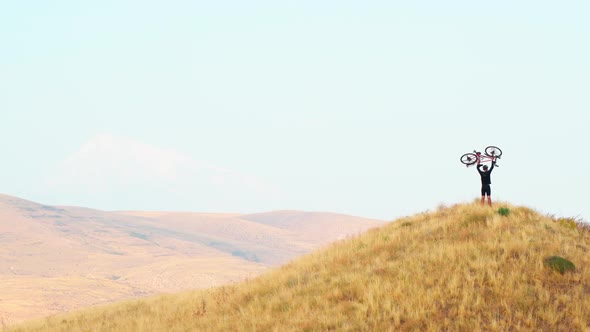 Slow Motion Cyclist Lifting Bicycle Up alt