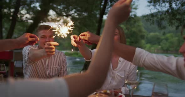 Youth Friendship Concept  Hands Toasting Red Wine Glass Beside River at Nightime alt