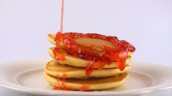 American pancakes with strawberry topping on a white background. alt