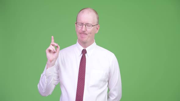 Happy Mature Bald Businessman Smiling and Thinking alt