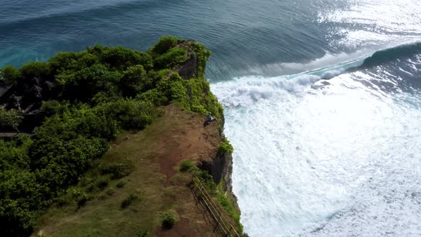 Man Sits on the Clifftop Above Ocean alt