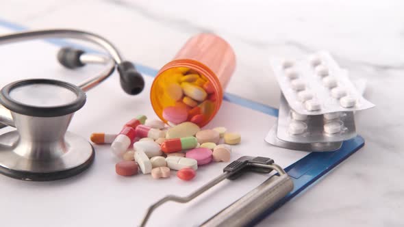 Thermometer  Stethoscope and Pills Container on Pink Background alt