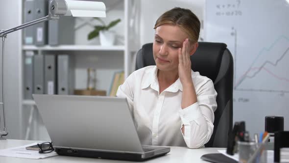 Woman Boss Massaging Temples Working on Laptop, Suffering Headache Stressful Job