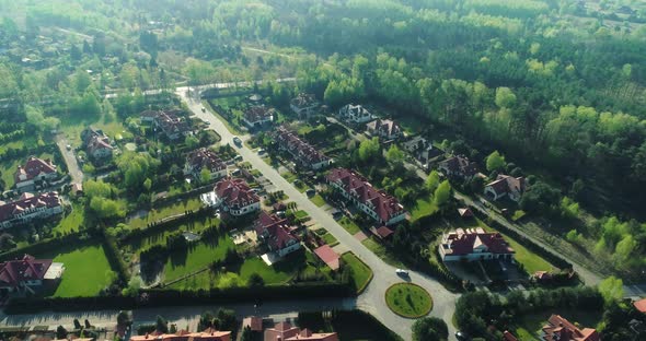 Aerial view of a housing estate in the suburbs surrounded by forest. alt