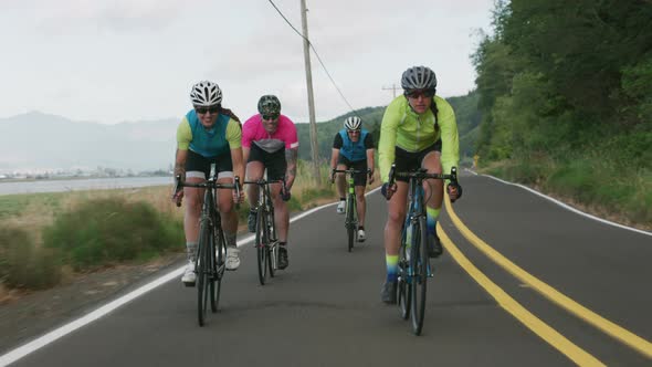 Tracking shot of a group of cyclists on country road.  Fully released for commercial use.