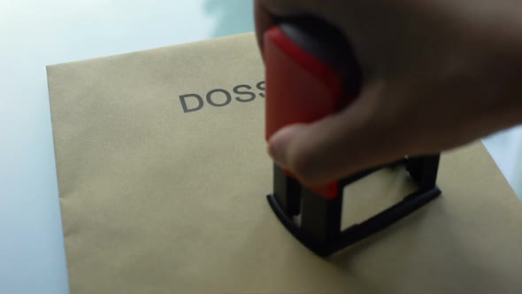 Dossier Top Secret, Hand Stamping Seal on Folder With Important Documents alt