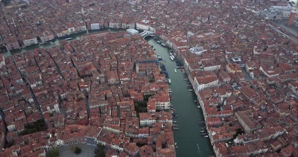 Wide aerial shot of Canal Grande and flying towards Ponte di Rialto from above at dusk, Venice, Ital alt