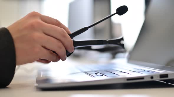 A Female Call Center Operator Removes the Headset and Puts It on the Laptop Keyboard at the End of alt