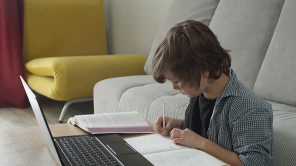 Boy Studying From Home During Pandemic Finishes Homework and Rejoicing Shouting Yes with Satisfied