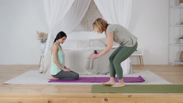 Female Yoga Instructor and Yomg Woman Preparing for Private Lesson at Home alt