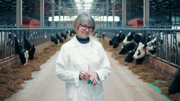 Cow Farm with a Female Specialist Holding a Milk Sample alt