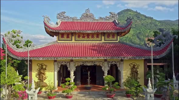 Flycam Moves Up From Temple Stairs To Over Red Roofs alt