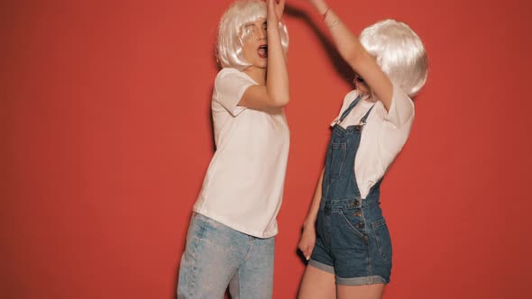 Two carefree young girls going crazy in studio alt